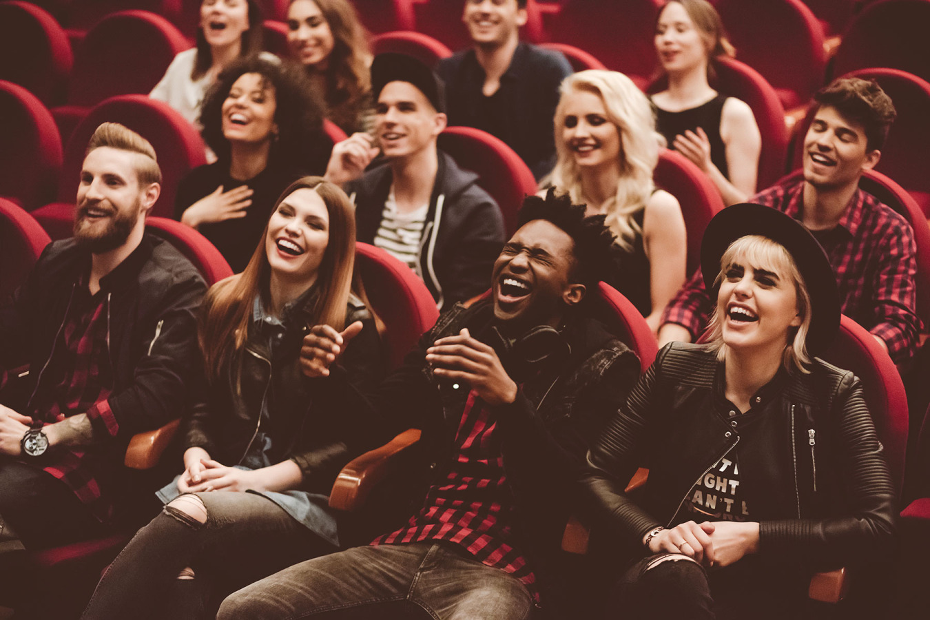 Theatre patrons reacting with laughter in auditorium