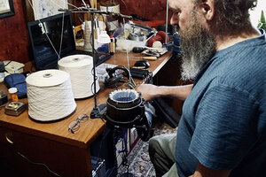 Man sits at mending machine.