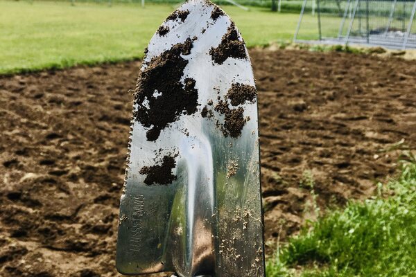 Spade in front of large garden bed