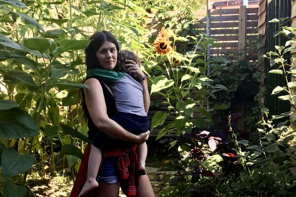 woman (mother) snuggles with child.